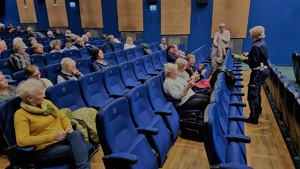 policjantka ruchu drogowego wręczająca seniorom opaski odblaskowe