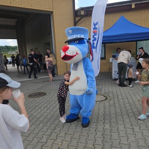 Zdjęcie przedstawia dziewczynkę przytulającą się do maskotki Sznupek